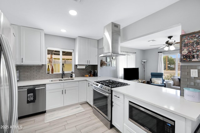 1615 E Roma Ave, Phoenix, AZ 85016 - kitchen with a sink, stainless steel appliances, island exhaust hood, a peninsula, and decorative backsplash