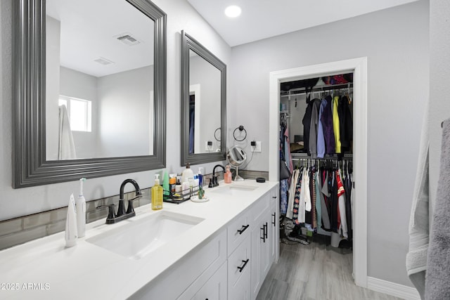 1615 E Roma Ave, Phoenix, AZ 85016 - bathroom with double vanity, a spacious closet, baseboards, and wood finished floors