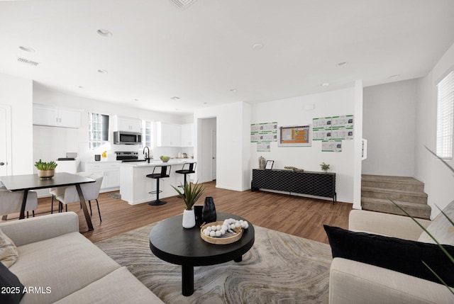 living area with wood finished floors and recessed lighting