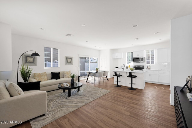 living area with wood finished floors and recessed lighting