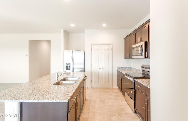 5029 S 252nd Ave, Buckeye, AZ 85326 - kitchen featuring appliances with stainless steel finishes, a sink, a kitchen island with sink, light stone counters, and recessed lighting