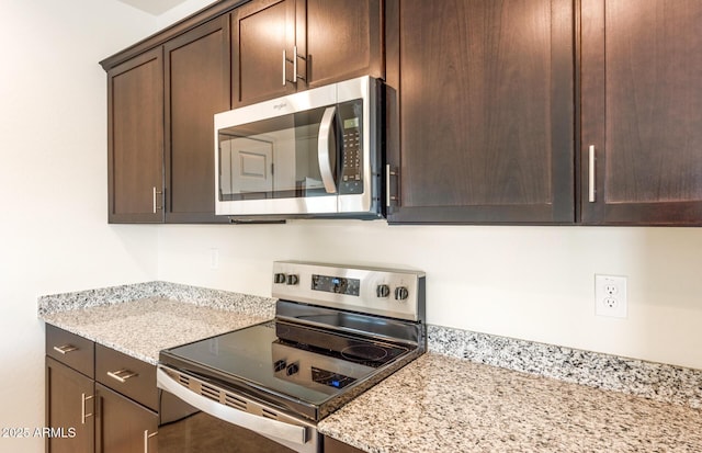 5029 S 252nd Ave, Buckeye, AZ 85326 - kitchen featuring appliances with stainless steel finishes, dark brown cabinetry, and light stone counters
