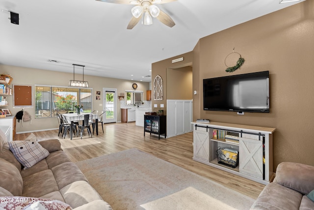 living room featuring light hardwood / wood-style floors and ceiling fan