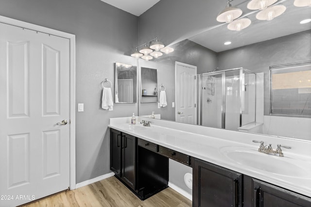 bathroom with vanity, hardwood / wood-style flooring, and a shower with door