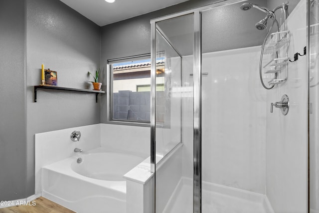 bathroom featuring shower with separate bathtub and hardwood / wood-style floors