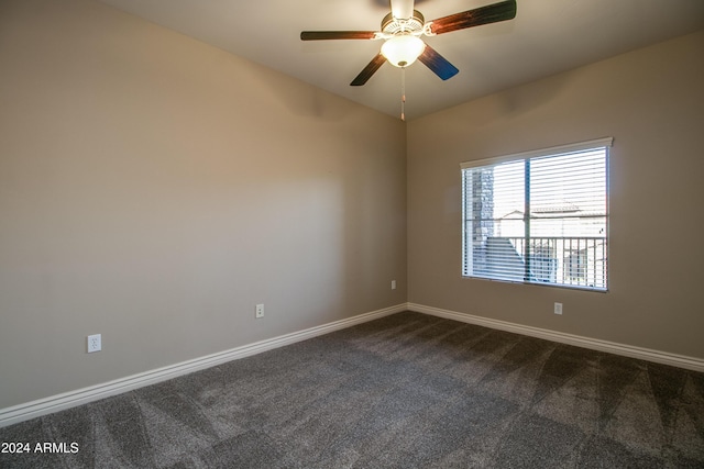 spare room featuring dark colored carpet and ceiling fan