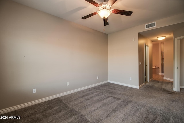 empty room with dark carpet and ceiling fan