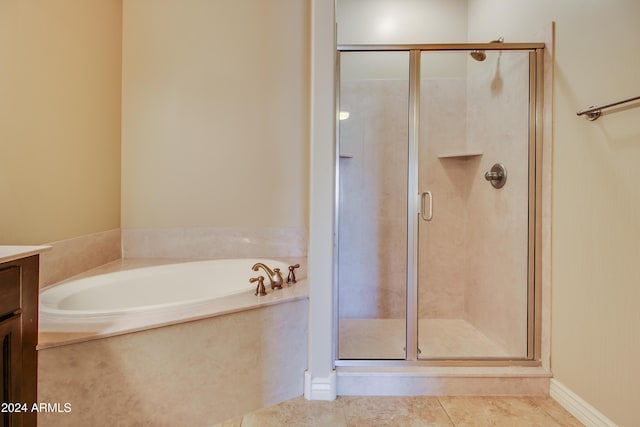 bathroom with tile patterned flooring, vanity, and plus walk in shower