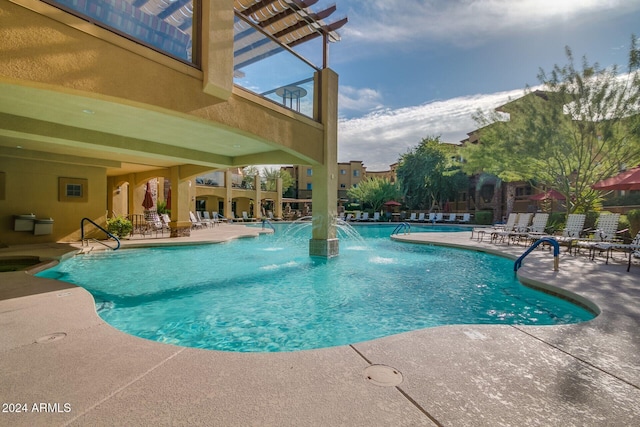 view of swimming pool featuring pool water feature and a patio