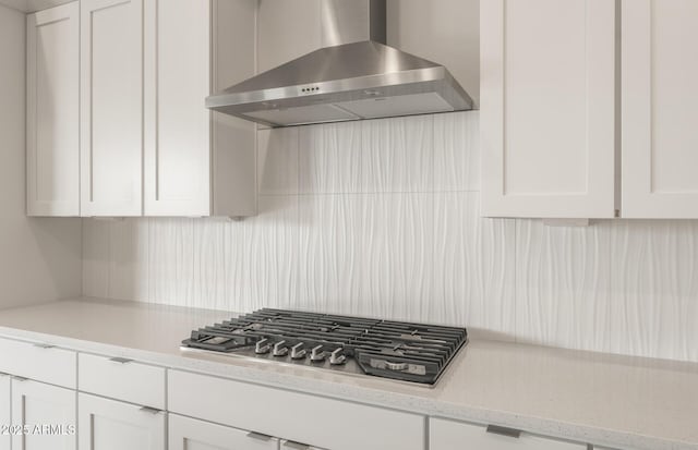 22660 E Pegasus Pkwy, Queen Creek, AZ 85142 - kitchen featuring wall chimney exhaust hood, stainless steel gas stovetop, white cabinets, decorative backsplash, and light stone countertops