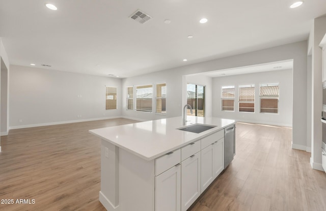 22660 E Pegasus Pkwy, Queen Creek, AZ 85142 - kitchen featuring a sink, dishwasher, open floor plan, light wood-type flooring, and an island with sink