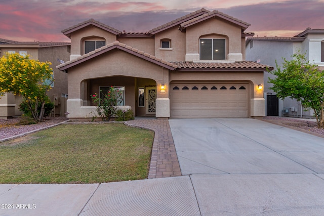 mediterranean / spanish-style house featuring a yard and a garage