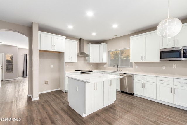20293 N 83rd Dr, Peoria, AZ 85382 - kitchen featuring appliances with stainless steel finishes, arched walkways, a sink, dark wood-style floors, and wall chimney exhaust hood