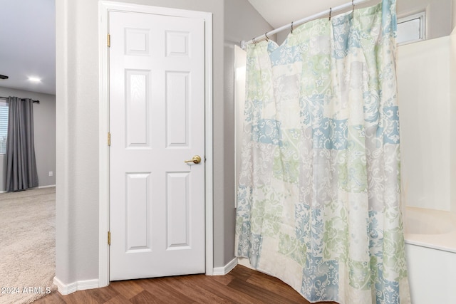 bathroom with hardwood / wood-style flooring and curtained shower