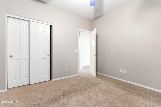 unfurnished bedroom with carpet floors, a closet, and ceiling fan