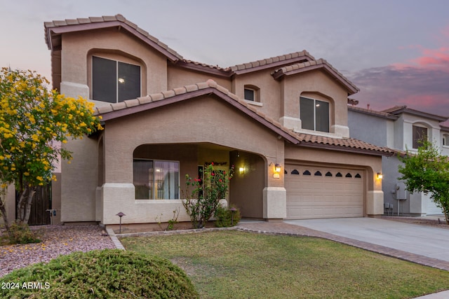 mediterranean / spanish-style home featuring a yard and a garage