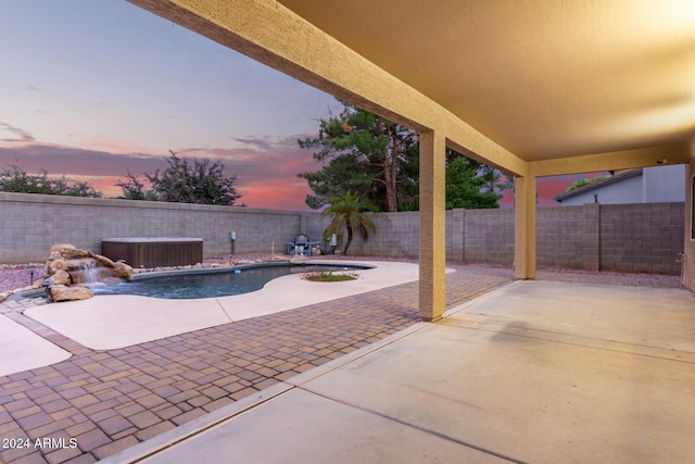 patio terrace at dusk featuring pool water feature, central AC, and a fenced in pool