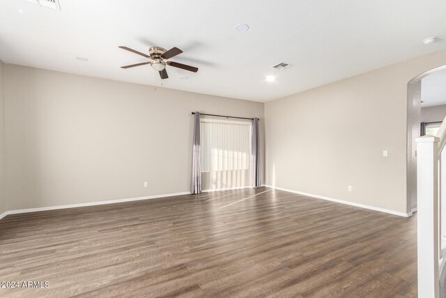 20293 N 83rd Dr, Peoria, AZ 85382 - empty room featuring arched walkways, a ceiling fan, baseboards, wood finished floors, and visible vents
