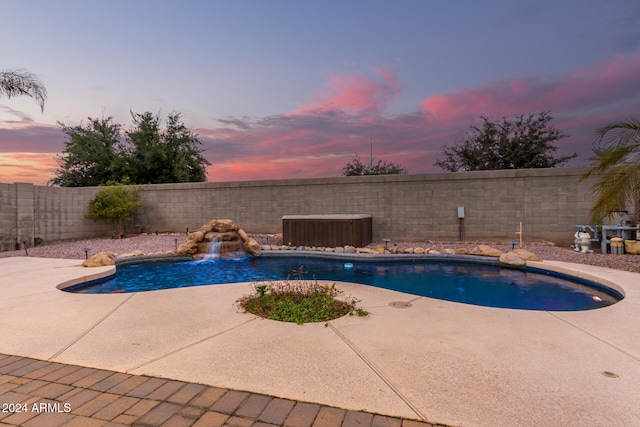 pool at dusk with a patio area, pool water feature, and central AC unit