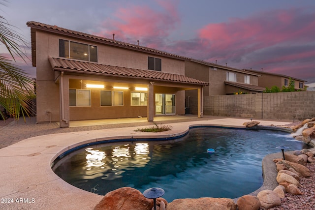 pool at dusk featuring a patio area