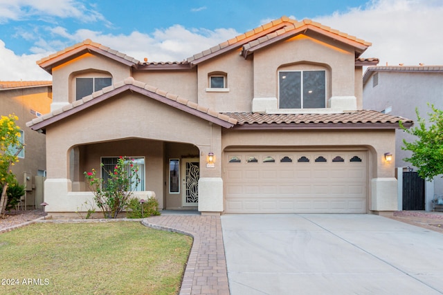 mediterranean / spanish-style house with a garage and a front lawn