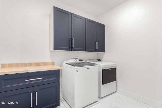 clothes washing area with washing machine and dryer and cabinets