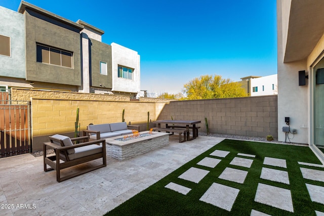 view of patio with an outdoor living space with a fire pit