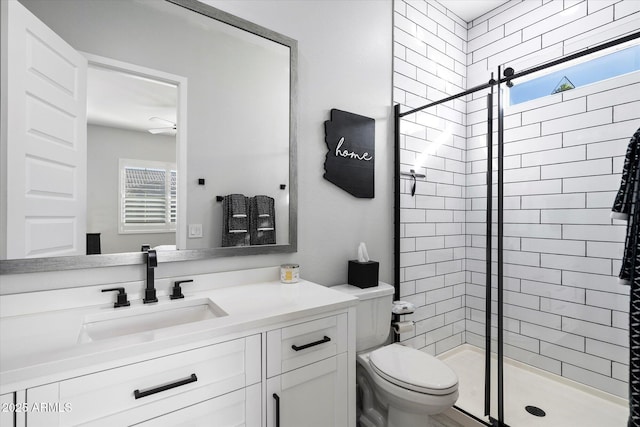 bathroom featuring toilet, vanity, and a shower with shower door