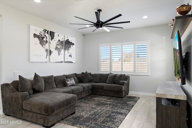 living room featuring ceiling fan and light hardwood / wood-style floors