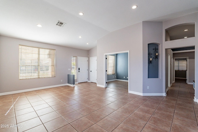 interior space featuring lofted ceiling and tile patterned flooring