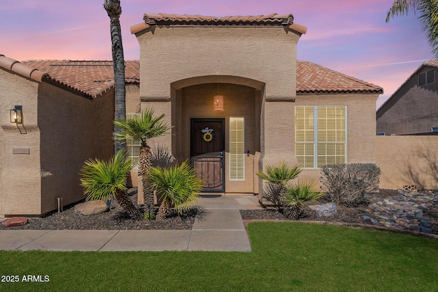 exterior entry at dusk with a lawn