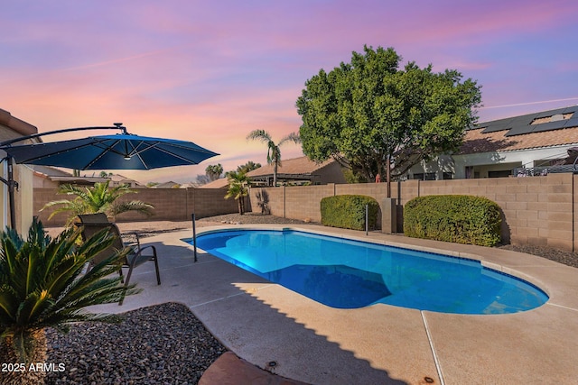 pool at dusk with a patio