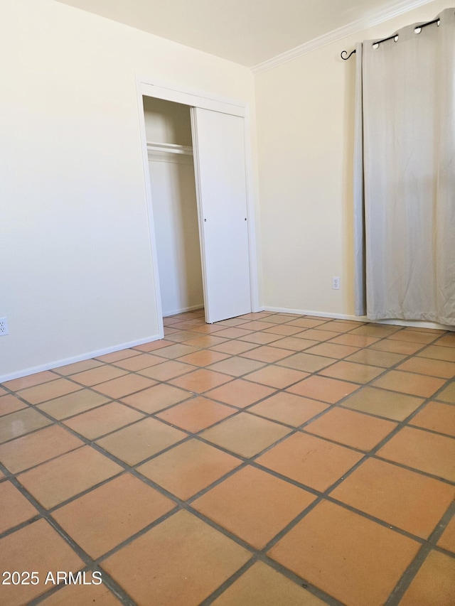 unfurnished bedroom featuring ornamental molding, a closet, and baseboards