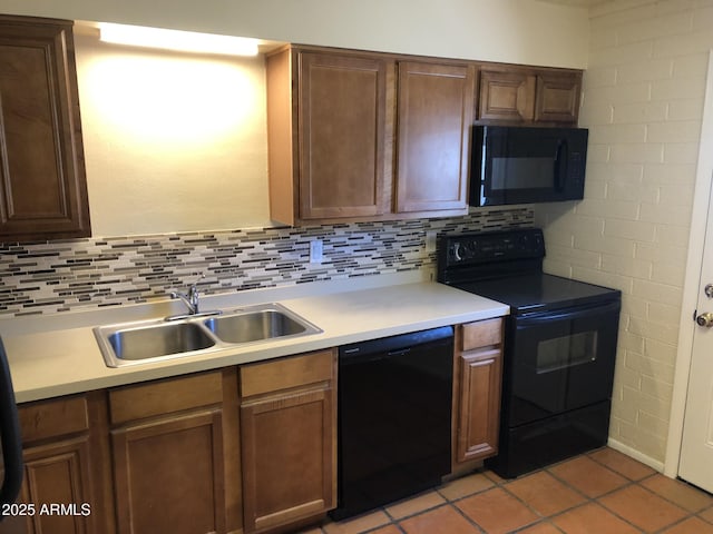 kitchen featuring black appliances, a sink, light countertops, and decorative backsplash