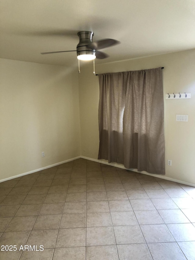 unfurnished room featuring light tile patterned floors, a ceiling fan, and baseboards