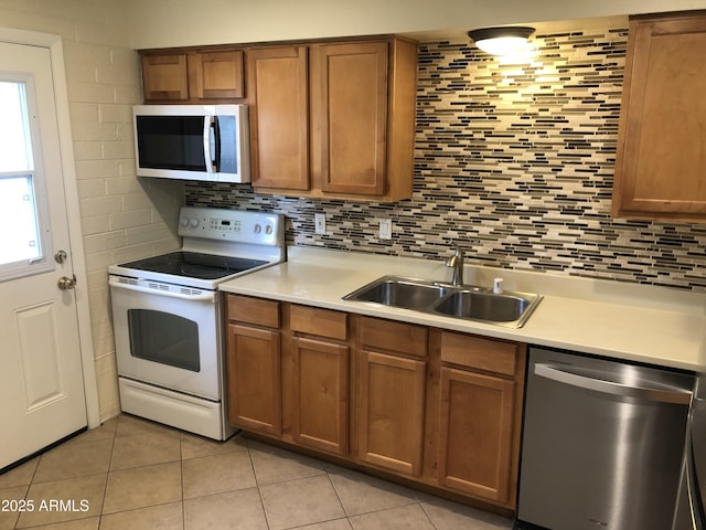 kitchen featuring decorative backsplash, stainless steel appliances, a sink, and light countertops