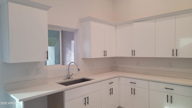 kitchen featuring white cabinetry and sink