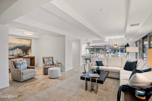 living room with a chandelier and beamed ceiling