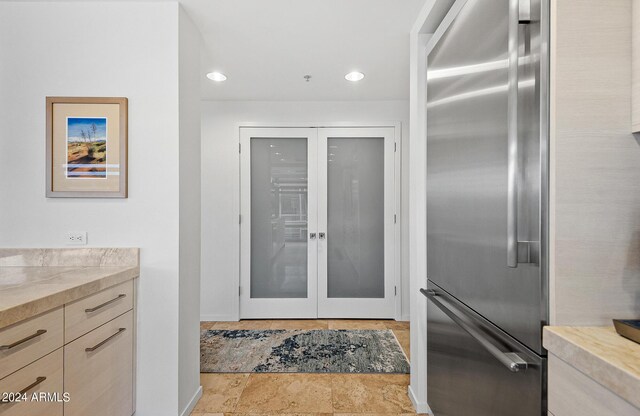 interior space featuring light brown cabinets and high end fridge