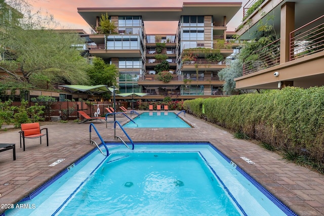 pool at dusk with a patio