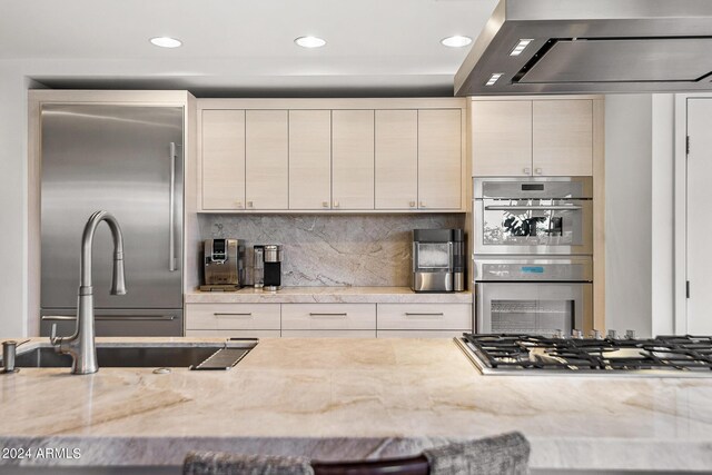 kitchen with island exhaust hood, a kitchen breakfast bar, stainless steel appliances, and light stone counters