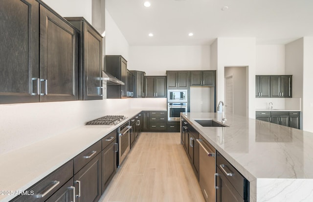 18716 N 269th Ln, Buckeye, AZ 85396 - kitchen featuring a sink, appliances with stainless steel finishes, a large island with sink, exhaust hood, and light stone counters