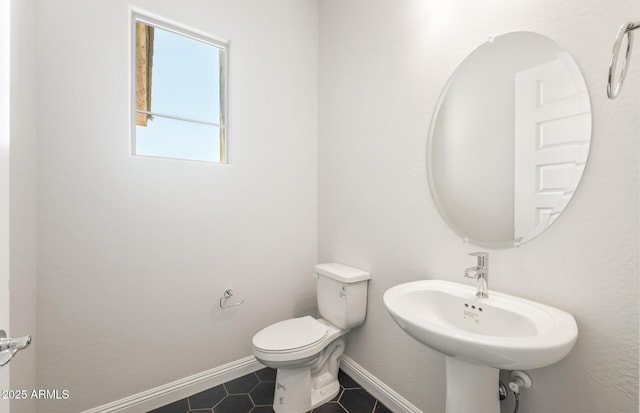 18716 N 269th Ln, Buckeye, AZ 85396 - half bath featuring tile patterned flooring, toilet, baseboards, and a sink