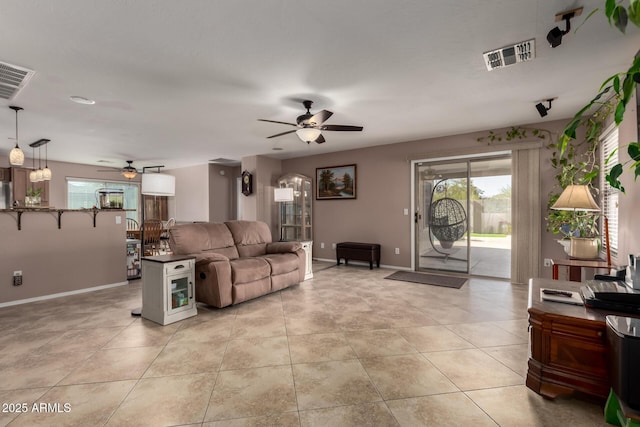 living room featuring visible vents, ceiling fan, baseboards, and light tile patterned flooring