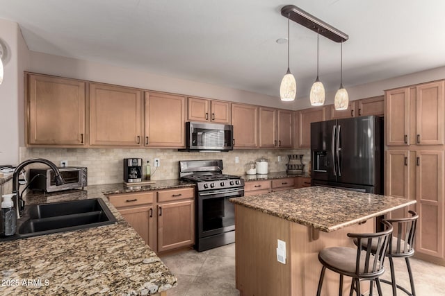 kitchen with stainless steel appliances, a sink, backsplash, and a kitchen breakfast bar