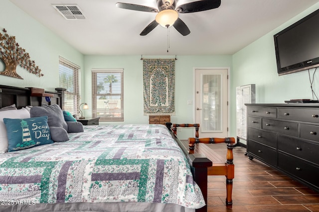 bedroom featuring dark wood-style flooring, visible vents, and ceiling fan