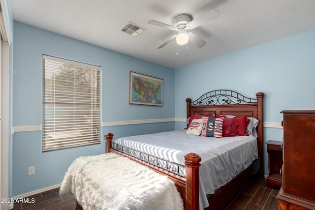 bedroom with baseboards, wood tiled floor, visible vents, and a ceiling fan