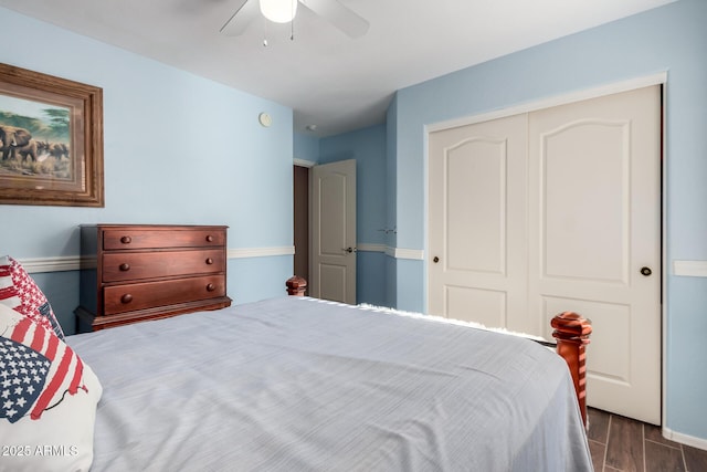 bedroom with a ceiling fan, dark wood finished floors, and a closet