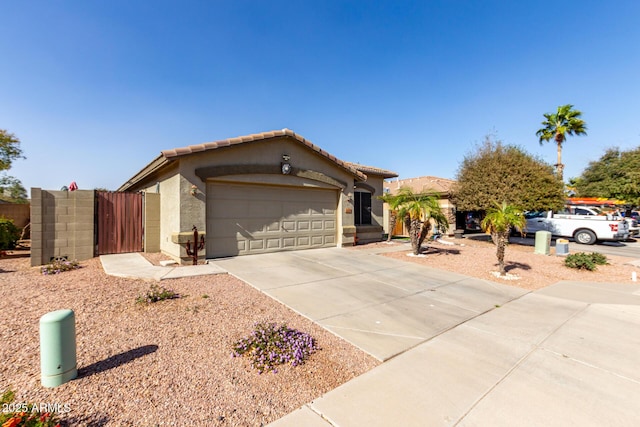 ranch-style house featuring an attached garage, a tiled roof, concrete driveway, and stucco siding