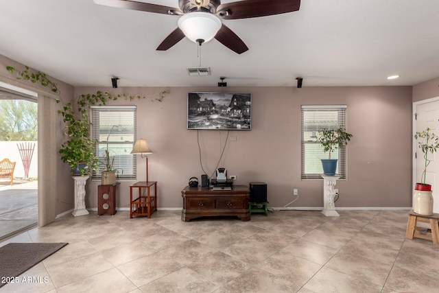 interior space featuring a ceiling fan, visible vents, baseboards, and light tile patterned flooring